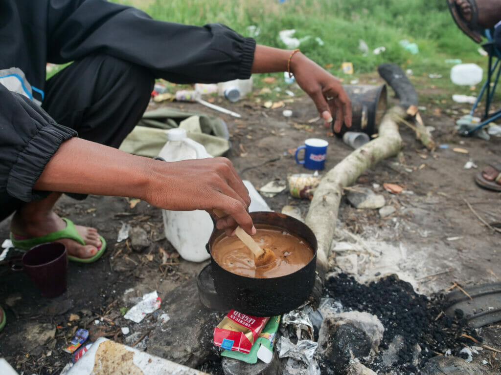 In Calais hoffen Mitte Juni rund 1000 Menschen auf einen Weg Richtung Großbritannien. Eine kaputte Mikrowelle dient als Ablage, auf offenem Feuer kochen die Menschen Kaffee.