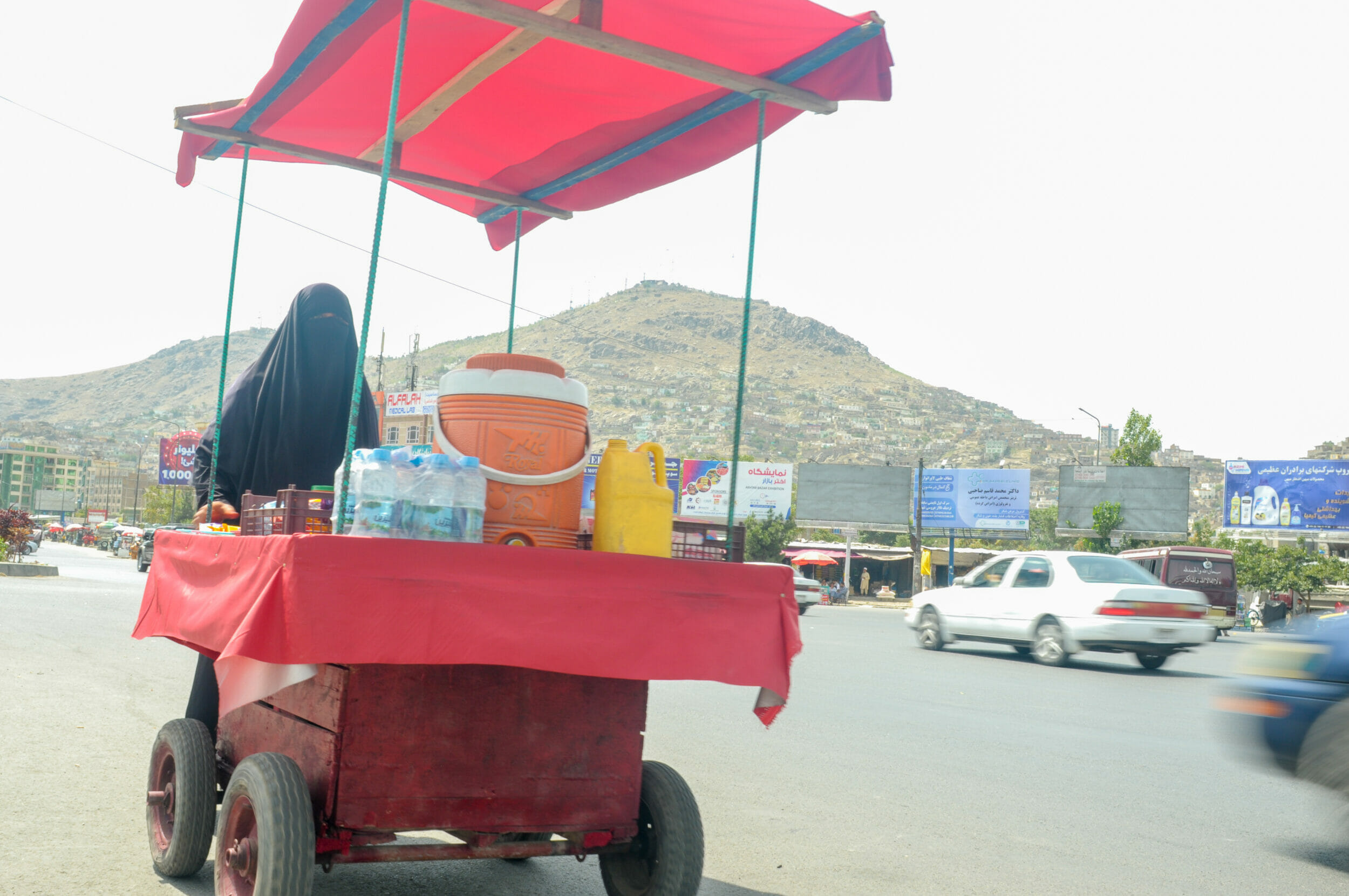 In Armut und schwarzem Gewand: Die Straßenverkäuferin von Kabul