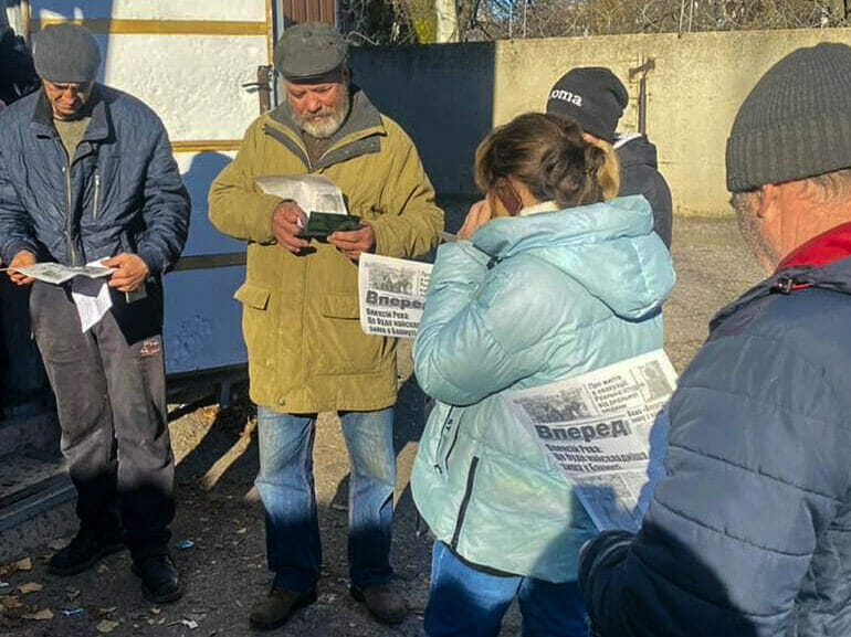 Bewohner:innen in Bachmut lesen eine Ausgabe der Wochenzeitung "Vpered". (Foto: Vpered)